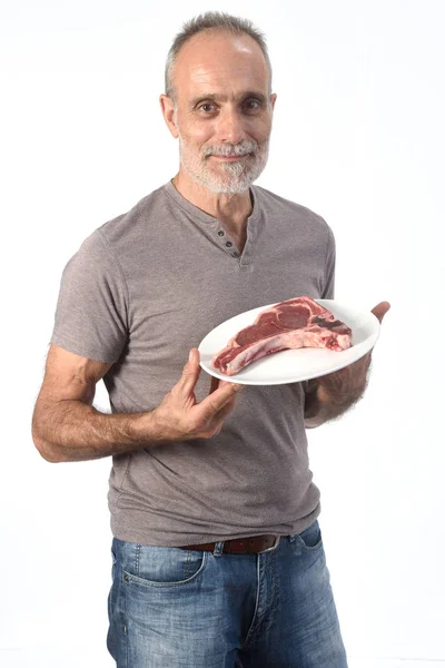 Uomo con bistecca cruda su sfondo bianco — Foto Stock