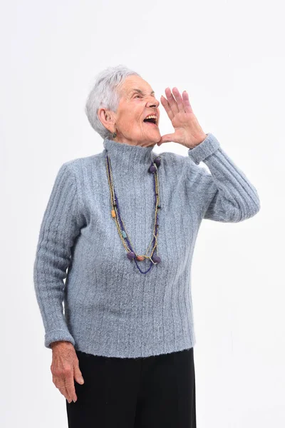 Senior kvinna sätta en hand i mun och skriker på vita b — Stockfoto