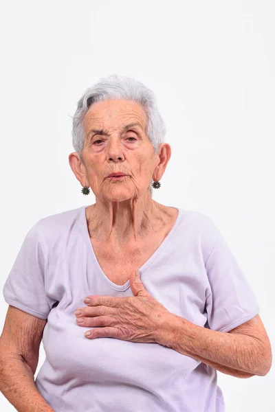 Donna anziana con la mano al cuore per uno spavento — Foto Stock