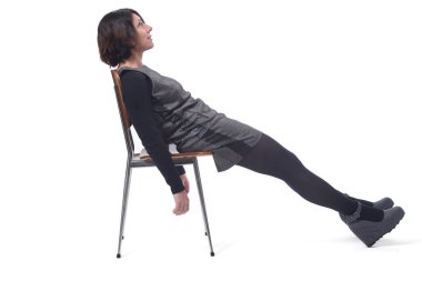 Beyaz arka planı olan bir sandalyede uzanan kadın.