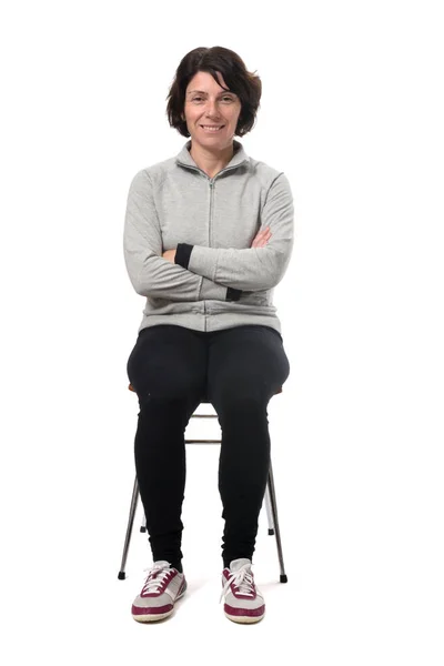 Portrait of a woman sitting on a chair in white background, arms — ストック写真