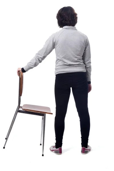 Frau steht auf einem Stuhl mit dem Rücken auf weißem Hintergrund — Stockfoto
