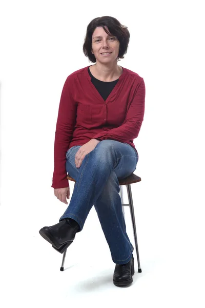 Portrait of a woman sitting on a chair on white background, legs — стоковое фото