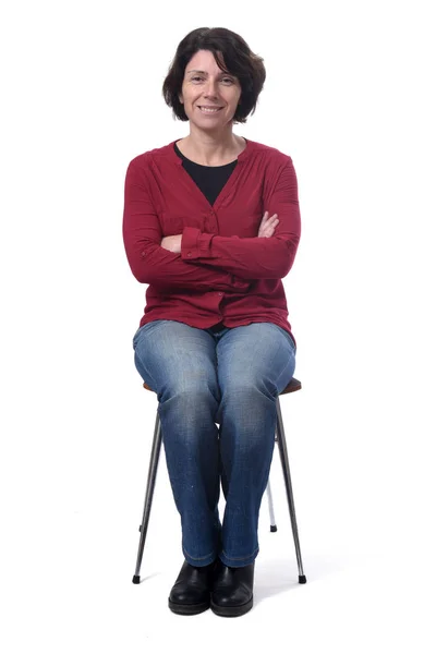 Portrait of a woman sitting on a chair on white background, arms — ストック写真