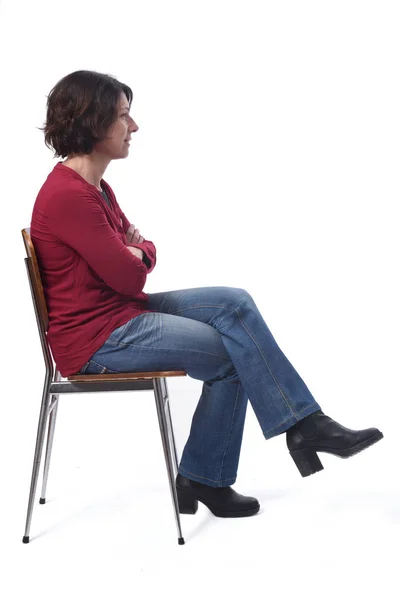 Portrait of a woman sitting on a chair in white background,look — ストック写真