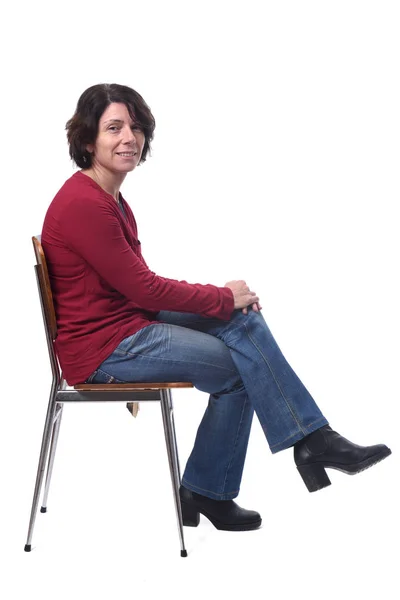 Portrait of a woman sitting on a chair in white background,looki — ストック写真