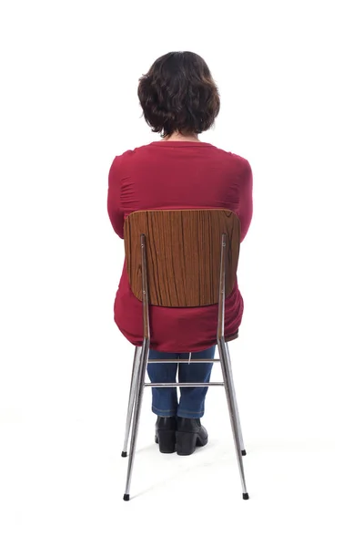 Woman sitting on a chair with her back on white background,arms — Stok fotoğraf