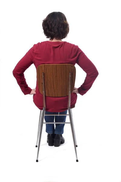 Woman sitting on a chair with her back on white background,hands — Foto de Stock