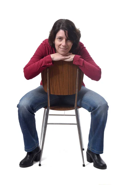 Porträt einer Frau, die auf einem Stuhl vor weißem Hintergrund sitzt — Stockfoto