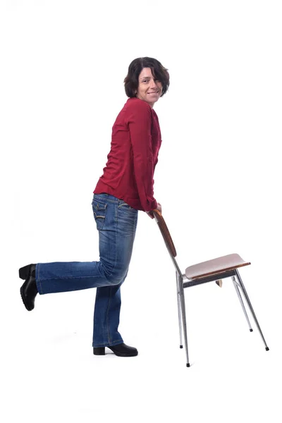Kvinna stående med en stol i vit bakgrund — Stockfoto