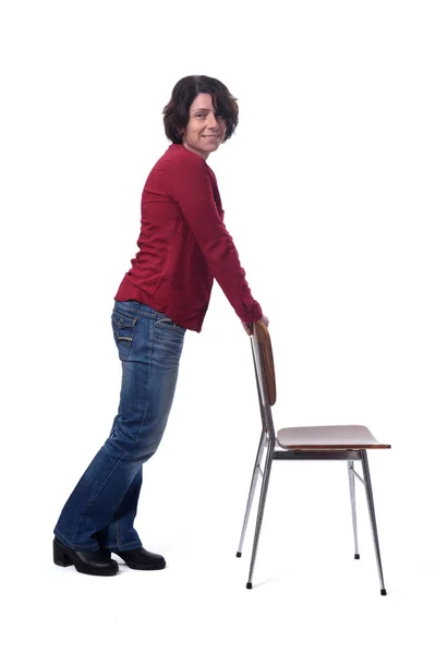Γυναίκα στέκεται με μια καρέκλα σε λευκό φόντο — Φωτογραφία Αρχείου