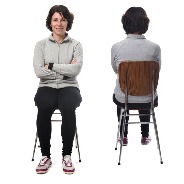Kvinna sitter på en stol rygg och front på vit bakgrund — Stockfoto