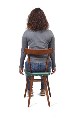 Beyaz arka planda sandalyede oturan bir kadının dikiz görüntüsü, 