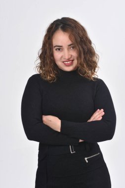 Kahverengi saçlı bir kadının portresi beyaz arka planda kameraya bakıyor.