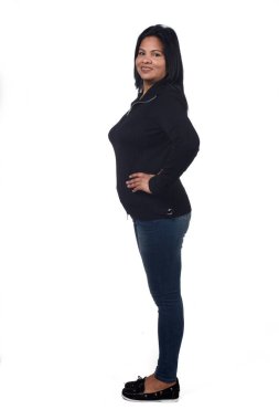 Kadın portresi beyaz, kollar kalçada ve kameraya bakıyor.