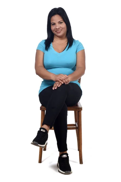 一个女人坐在白色背景的椅子上 前视镜和双腿交叉的肖像 — 图库照片