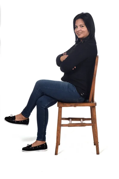 白い背景の椅子に座っている女性の肖像画足と腕が交差しカメラを見て — ストック写真