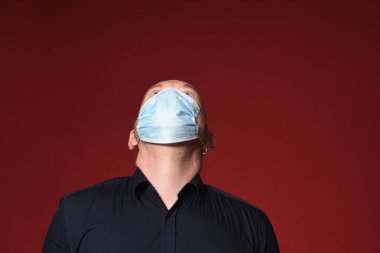 Maskeli bir adamın portresi. Kırmızı arka plana bak.