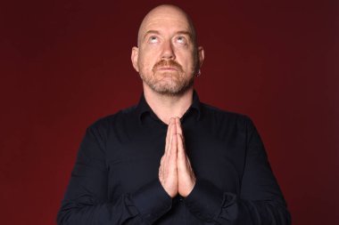 Kırmızı arka planda dua eden adam, yukarı bak.