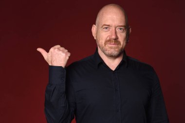 Kırmızı arkaplanda parmakla işaret eden adam