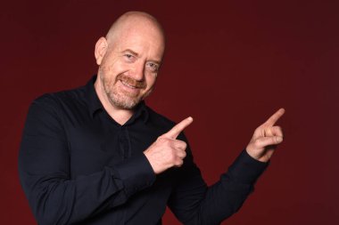 Kırmızı arka planda iki parmağı olan bir adam.