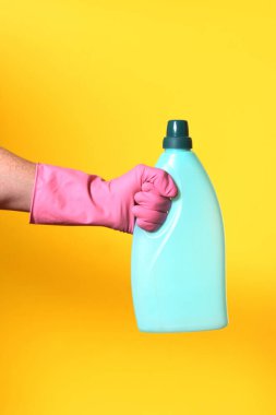 Sarı arka planda eldiven ve plastik sabunla.