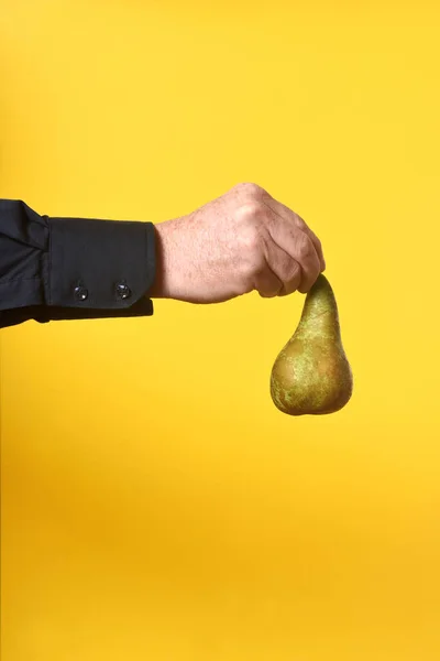 Mão Segurando Uma Pêra Fundo Amarelo — Fotografia de Stock