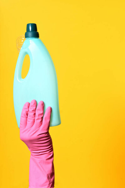 hand with gloves holding soap bottle