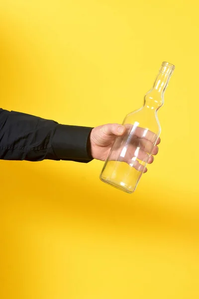Человек Держит Прозрачную Бутылку Желтом Фоне — стоковое фото