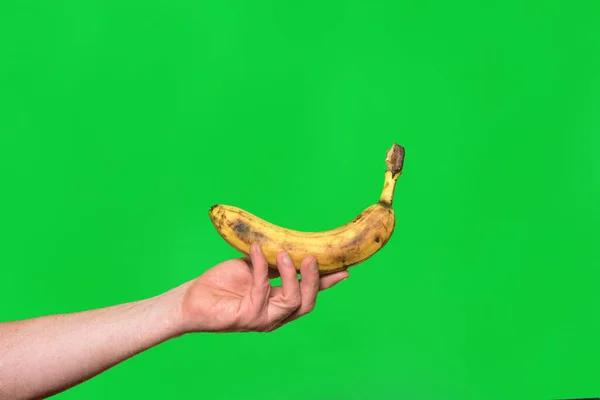 Рука Тримає Банан Зеленому Фоні — стокове фото