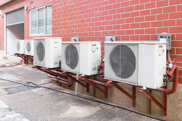 Kondensatory chłodzone powietrzem izolowane na ścianie z czerwonej cegły. — Zdjęcie stockowe