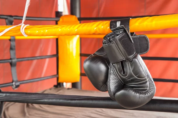 Luvas de boxe preto pendurar em pendurar em cordas de anel . — Fotografia de Stock