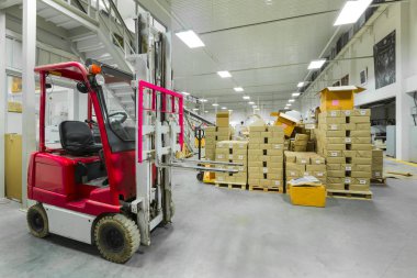 Forkliftlerle dolu modern bir depo.