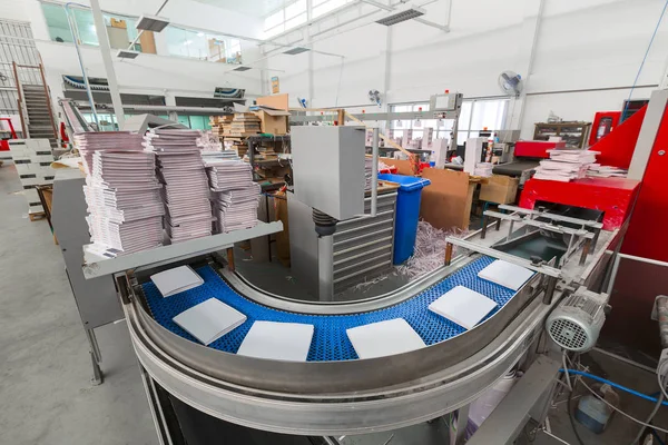 De transportband met tijdschriften. Afdrukken fabriek. Een stroom van journ — Stockfoto