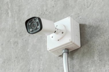Kapalı devre televizyon kamerası beyaz beton duvara yerleştirilmiş, güvenlik kamerası var..