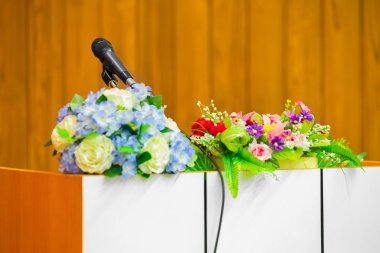 Mikrofon ayakta D'de içinde çiçek buketi bir masada