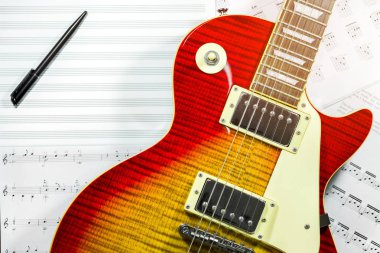 Elektro gitar ile arka planda müzik notlar.