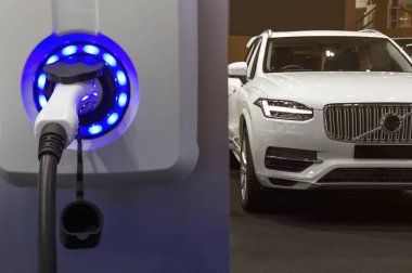 Elektrikli araba, şehir caddesinde elektrikli araba şarj istasyonuyla park yerinde şarj oluyor. Şarj edilen bir elektrikli arabaya takılan güç kaynağını kapatın..