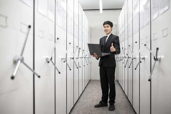 Business man, bank manager using notebook in a locker server roo — Stock Photo, Image