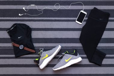 Bangkok, Tayland - 12 Ağustos 2018: Nike KAISHI 2.0 SE Run Shoes, DRI-FIT Cool Breeze, capri ürünü tam kadın pantolonu taytı, akıllı telefon uygulaması gri halı üzerinde izole edilmiş.