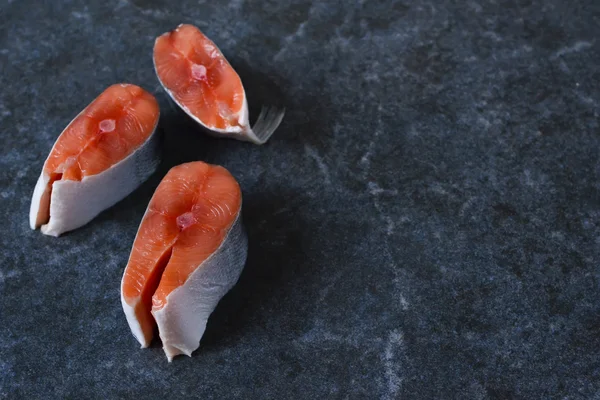 Filete fresco de salmón crudo sobre fondo de mármol negro — Foto de Stock