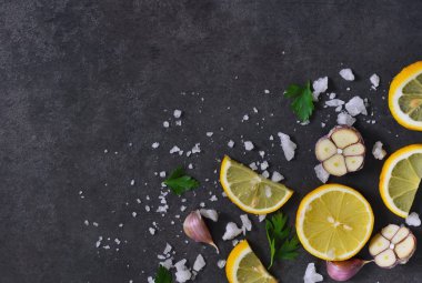 Siyah gıda arka plan dilim limon, tuz ve sarımsak ile 