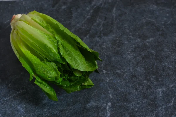 Alface Romaine em fundo de mármore preto . — Fotografia de Stock