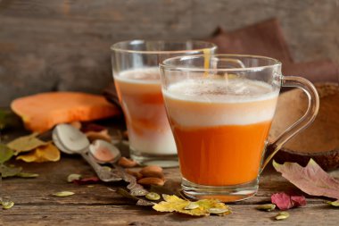 Sütü, badem ve kabak ahşap arka plan üzerinde ev latte