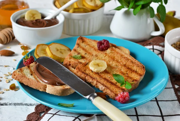 Good morning - toast with walnut, chocolate paste, banana and honey. White food background. — Stock Photo, Image