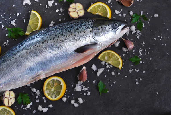 Färsk rå lax med salt och citron på en svart bakgrund. — Stockfoto