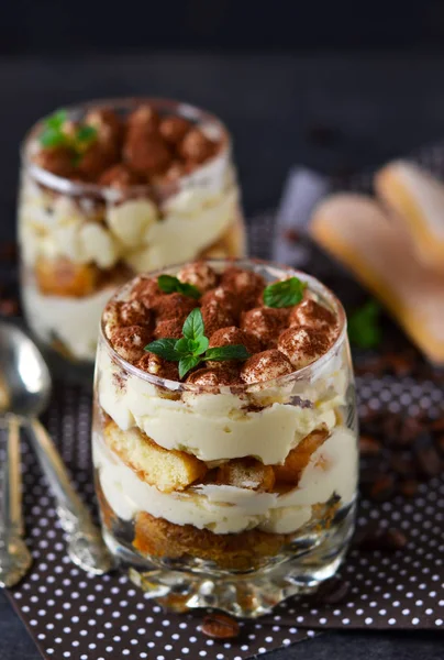 Tiramisu clássico em um frasco de vidro no fundo preto — Fotografia de Stock