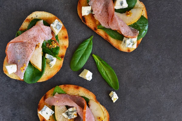 Toast with sauce, ham, pear and blue cheese — Stock Photo, Image