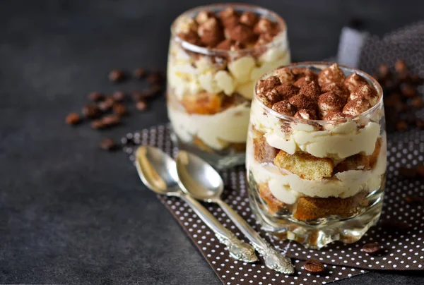 Tiramisu clássico em um frasco de vidro no fundo preto — Fotografia de Stock