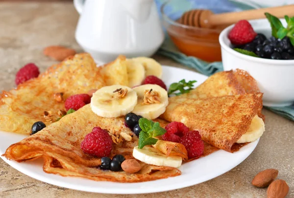 Homemade pancakes with banana, berries and honey for breakfast. — Stock Photo, Image